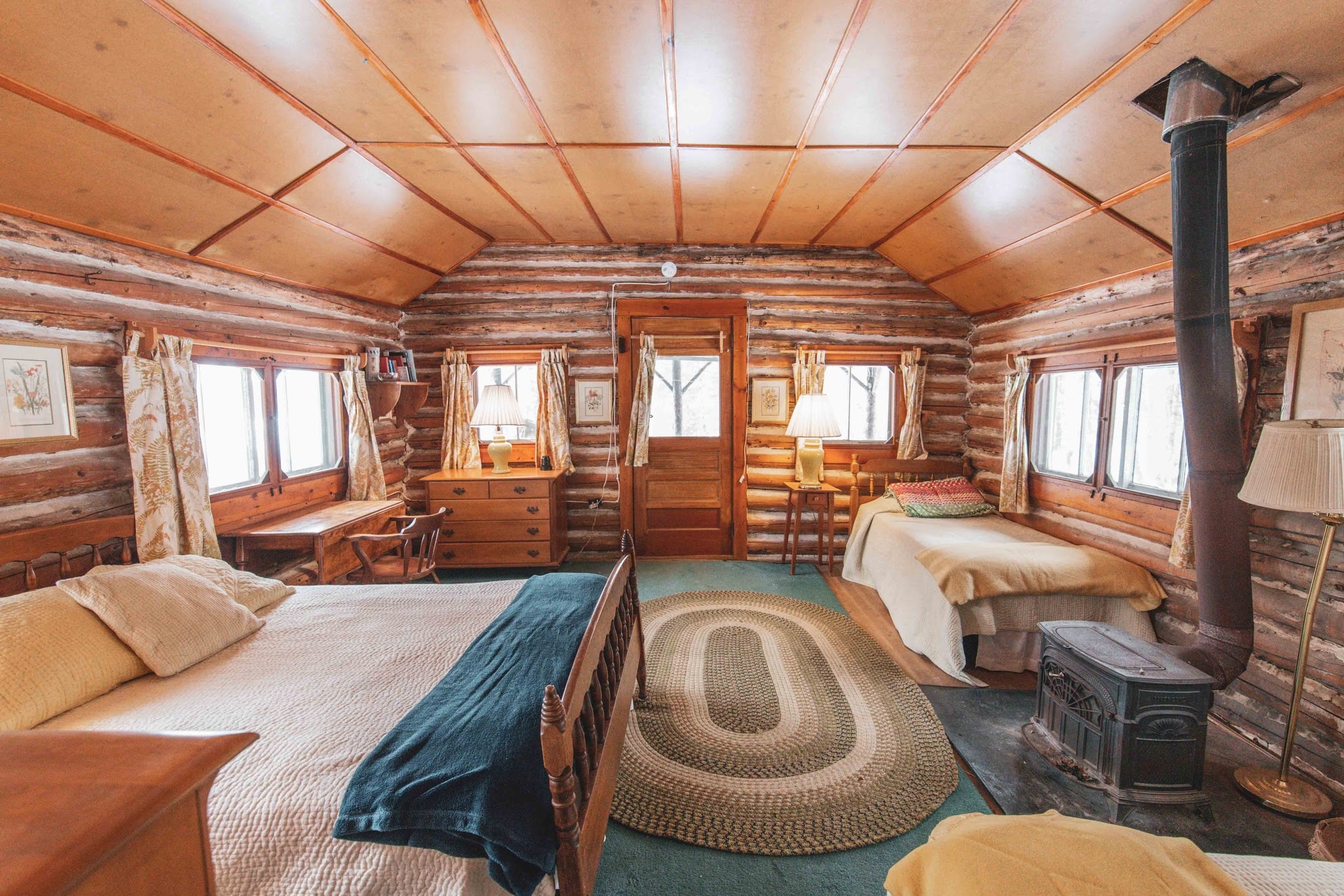 Log cabin interior with woodstove and cozy beds