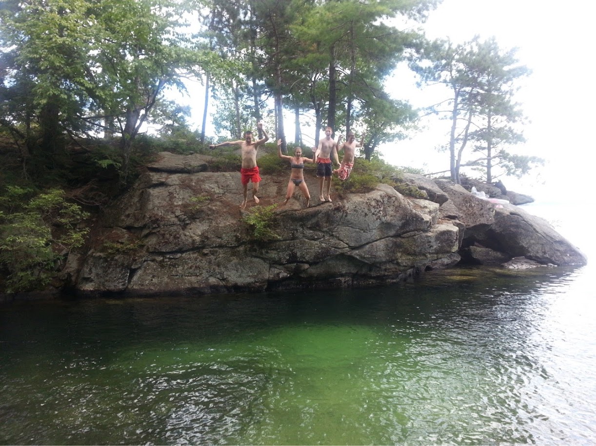 Anna and Alex jumping off Rock Island at Three Mile Island Camp